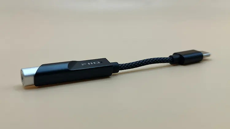Convertidor DAC portátil FiiO KA11 con salida 3.5mm y alta potencia, sobre fondo amarillo.