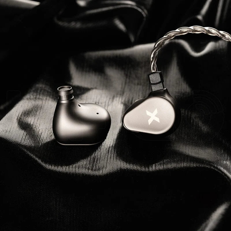 Auriculares in-ear DUNU Titan X con driver dinámico de 10mm, doble cámara y doble imán, detalles visibles en los monitores.