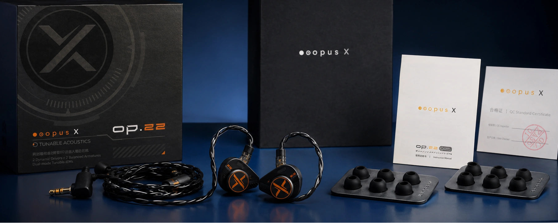Opus X headphones and accessories on a dark surface with branded packaging.